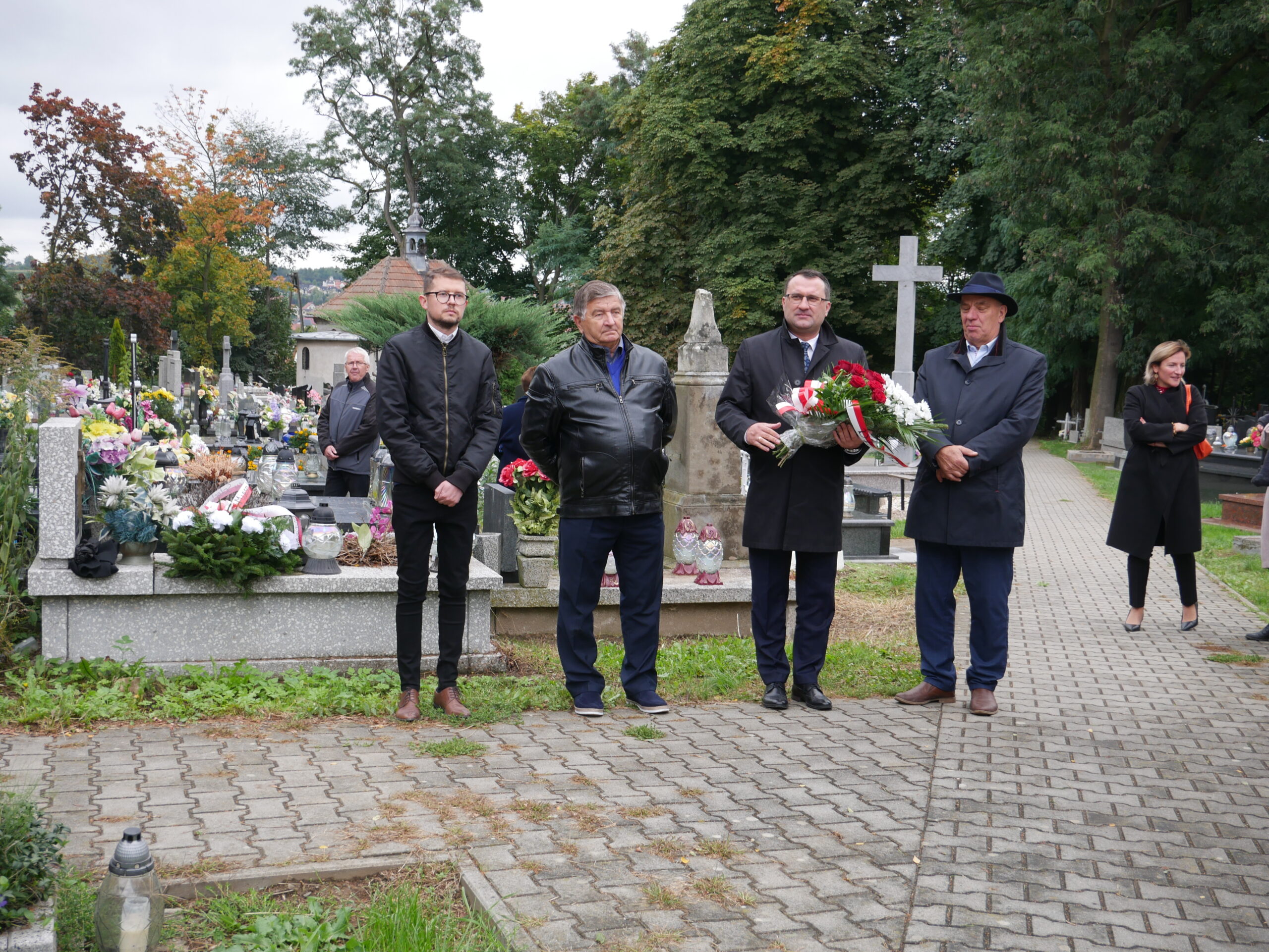 zdjęcie przedstawia czterech mężczyzn na cmentarzu