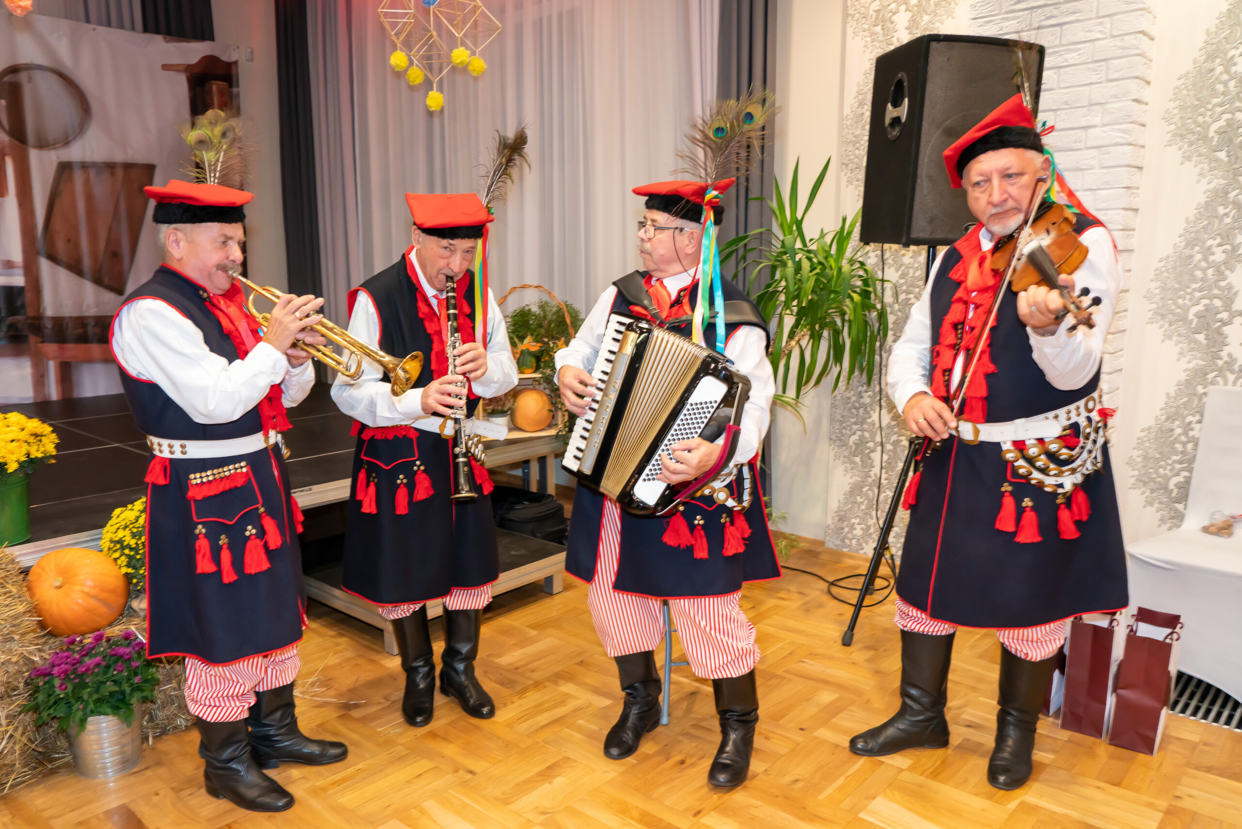 zdjęcie przedstawia czterech mężczyzn w strojach krakowskich grających na instrumentach