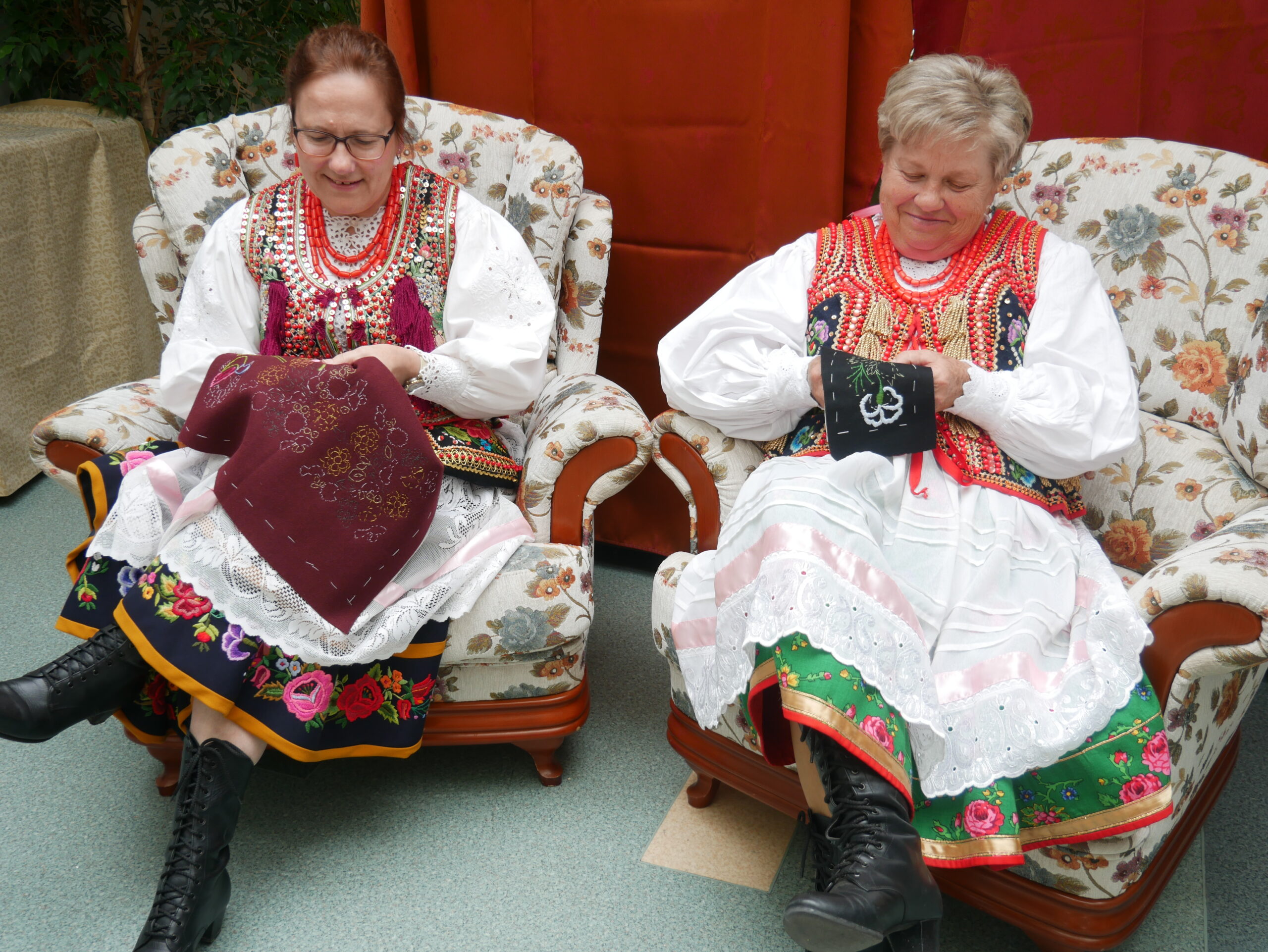 na zdjeciu widoczne kobiety w strojach krakowskich siedzące na fotelach